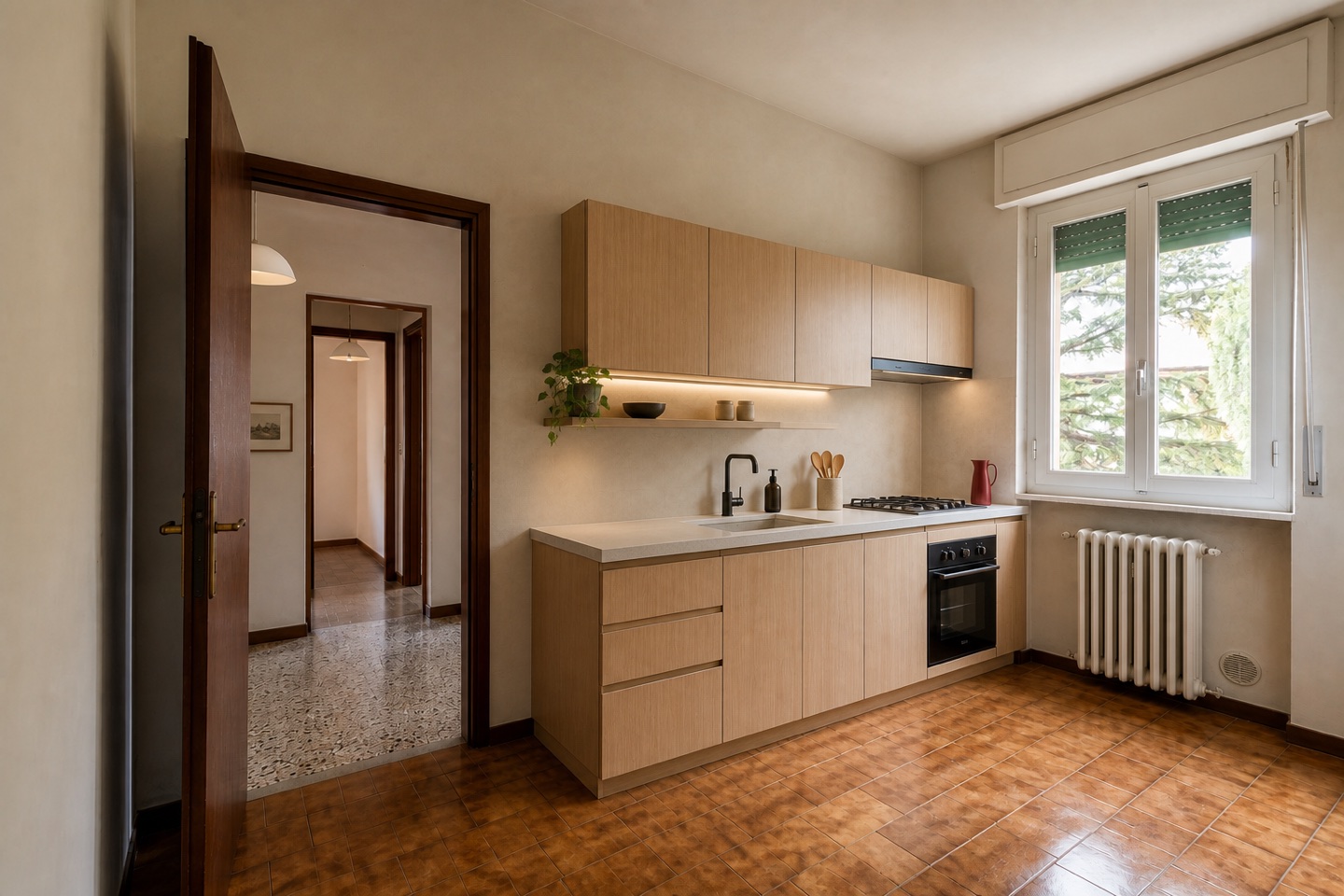 La stessa cucina dopo la ristrutturazione, con rovere chiaro e finiture materiche